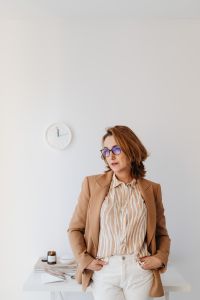 Kaboompics - Woman in Camel Blazer with Wall Clock and Copy Space