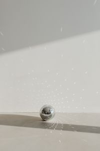 Kaboompics - Small Disco Ball Beneath Reflected Party Lights on a Blank Wall