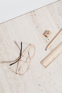 Kaboompics - Wire-Frame Reading Glasses on Textured Limestone, Minimal Study Desk Still Life