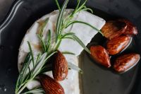 Kaboompics - Camembert Wheel with Rosemary Sprigs and Almonds on Black Plate