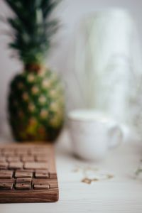 Kaboompics - Soft Focus Pineapple and Coffee beside a Wooden Keyboard