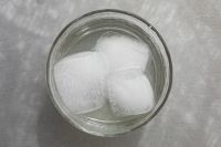 Kaboompics - Top-Down Glass of Ice Water with Two Cubes on Pale Marble, Clean Minimal Summer Drink Photo