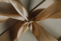 Kaboompics - Ivory and Gold Ribbon Bow on Gift Box, Horizontal Holiday Wrapping Detail