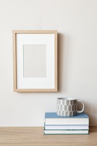 Kaboompics - Minimal Empty Frame Mockup with Patterned Mug and Books on a Blue Book