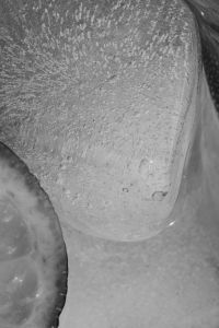Kaboompics - Extreme Macro of a Large Ice Cube in Water, Curved Glass Edge and Abstract Chilled Drink Texture
