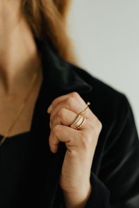 Kaboompics - Woman Adjusting Black Blazer with Gold Rings