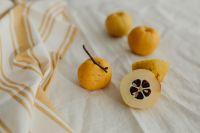 Kaboompics - Japanese Quince Still Life with Whole Fruit and Seeded Cut Half on Striped Linen