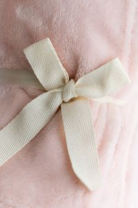 Kaboompics - Soft Pink Blanket With Ribbon Detail Close Up