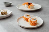Kaboompics - Two Orange Tobiko Maki Rolls on a Plate with Copy Space