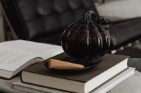 Kaboompics - Black Pumpkin on Books and Wooden Tray