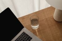 Kaboompics - Close-Up of a Drinking Glass Beside Laptop on Oak Desk