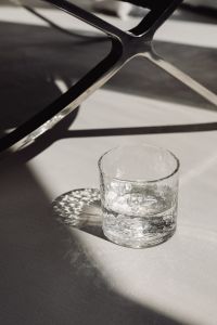 Kaboompics - Single Water Tumbler Framed by Structural Chair Shadows