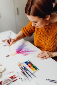 A woman paints with watercolors