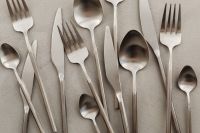 Kaboompics - Minimal Stainless Steel Cutlery Pattern on Textured Gray Background