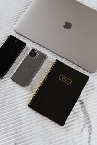 Kaboompics - Overhead Workspace with Two Phones, Silver Laptop and 2020 Notebook