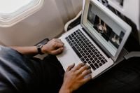 Kaboompics - Unrecognizable man with notebook sitting inside an airplane