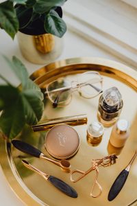 Kaboompics - Makeup essentials on a golden tray
