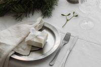 Kaboompics - White Christmas Place Setting with Wrapped Gift, Silver Pitcher, Cutlery and Mistletoe