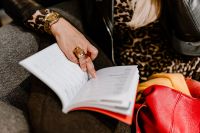 Kaboompics - A woman with a large ring and a golden watch writes down in the calendar