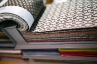 Kaboompics - Close-Up of Black-and-White Woven Upholstery Fabric Rolled over Colorful Textile Swatches
