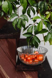 Kaboompics - Leafy Potted Plant and Cherry Tomatoes on a Rustic Wooden Stand