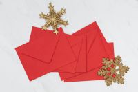 Kaboompics - Red Envelopes with Gold Glitter Snowflakes on White Marble