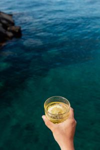 Kaboompics - Yellow Beverage in Hand against Deep Blue-Green Sea