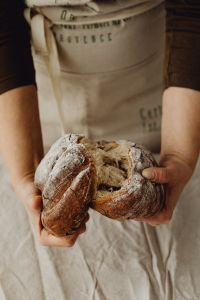 Kaboompics - Hands Holding Two Rustic Bread Loaves