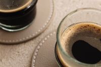 Kaboompics - Macro View of Espresso Glasses on a Taupe Stitched Coaster