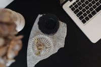 Kaboompics - Overhead Laptop Desk with Black Candle, Gold Binder Clips and Marble Slab