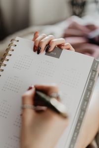 Kaboompics - Writing in a notebook lying in bed, with coffee, candles, and gingerbreads