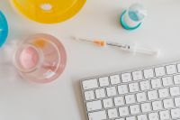Kaboompics - Laboratory Syringe Beside Pink Flask and Keyboard