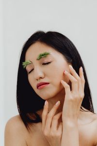 Kaboompics - Eyes-Closed Beauty Close-Up with Hand at Cheek and Grass Eyebrow Styling
