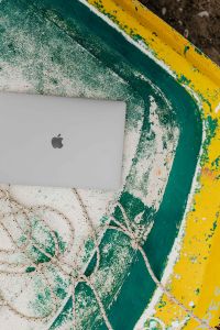 Kaboompics - Closed MacBook in a Weathered Yellow and Green Boat