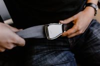 Kaboompics - Close up of man hands fasten belts while sitting on airplane seat