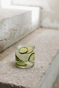 Kaboompics - Minimal Cucumber and Lime Detox Water with Ice on Sunlit Concrete Steps, Vertical Summer Background with Copy Space