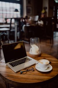 Kaboompics - Cup of coffee & MacBook laptop, glasses on table in cafe