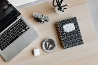 Kaboompics - Top View of Laptop, Camera, AirPods and Notes Notebook