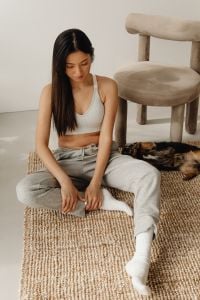 Kaboompics - Woman Sitting Beside a Beige Accent Chair in a Minimal Living Room