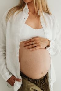 Kaboompics - Pregnant Woman in a White Shirt Holding Her Belly