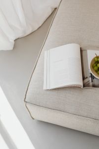Reading Magazine and Green Grapes on a Textured Sofa Cushion