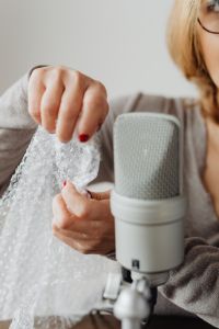 Kaboompics - Close-Up Fingers Handling Bubble Wrap with Microphone in Soft Focus, ASMR