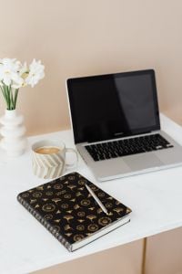 Kaboompics - Neutral Laptop Workspace with White Flowers, Planner and Pen