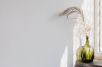 Kaboompics - Green Glass Bottle Vase with Dried Pampas Grass by Sunlit Window for Neutral Home Decor