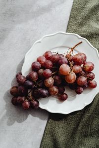 Kaboompics - Red Grapes in a White Ceramic Dish on Olive Green Fabric