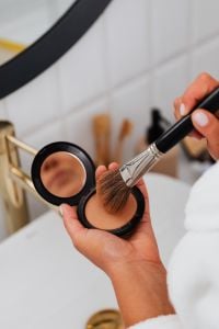 Kaboompics - Makeup Brush Dipping into Pressed Powder Compact, Close-Up Beauty Routine