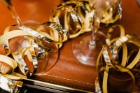 Kaboompics - Curled Gold Party Ribbon Beside Champagne Glass on Dark Table
