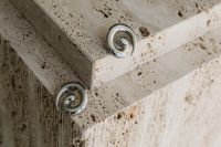Kaboompics - Silver Spiral Earrings on the Corner of a Stone Pedestal