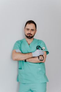 Kaboompics - Male Doctor in Mint Scrubs Holding a Stethoscope, Vertical Medical Education Portrait