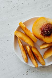 Kaboompics - Close-Up of Sliced Peach on White Plate, Minimal Food Background